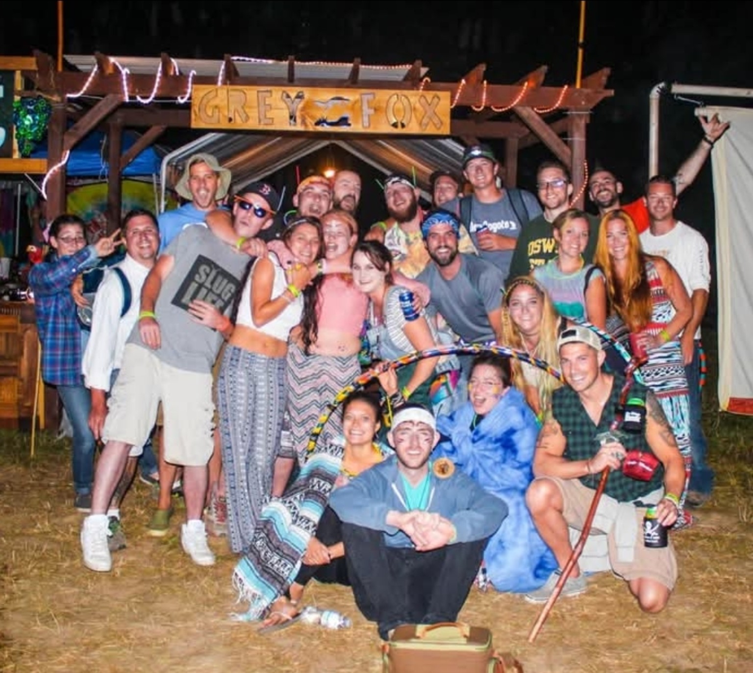 A group gathered beneath the Grey Fox sign at a festival